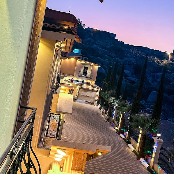 Un hotel con balcón, mobiliario exterior y vistas al paisaje circundante.