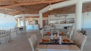 Ein Restaurant mit Außenbereich, einer Bar und Meerblick.