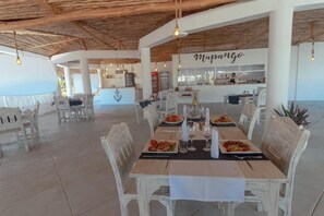 Ein Restaurant mit Außenbereich, einer Bar und Meerblick.