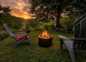 A fire pit with chairs and a tree in a grassy outdoor area. - Guthrie Ridge-Charming Getaway, Gorgeous Views! (Waynesville)