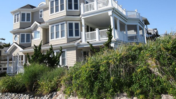A multi-story house with a balcony, surrounded by vegetation. - Surf City Oceanfront Property (Surf City)