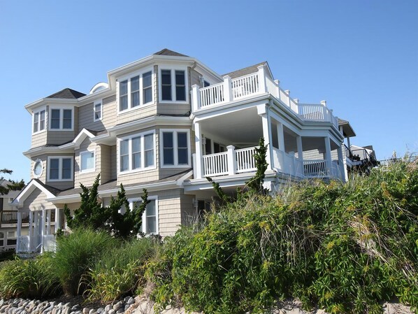 A multi-story house with a balcony, surrounded by vegetation. - Surf City Oceanfront Property (Surf City)