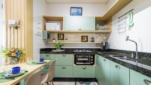 Una cucina compatta con forno a incasso, lavello e zona pranzo con tavolo e sedie.
