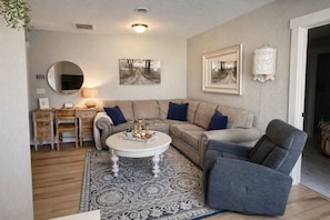 Un salon comprenant un canapé, un fauteuil, une table basse et un tapis.