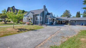 A two-story house with a covered porch, a garage, and a driveway. - Thompson Cottage - Sleeps 4 (Sedro-Woolley)