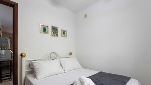 A bedroom with a bed, a bedside table, and a wall-mounted light fixture. - House With Barbecue Grill (Picarras)