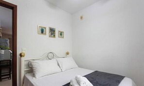 Ein Schlafzimmer mit einem Bett, einem Nachttisch und einer Wandleuchte.