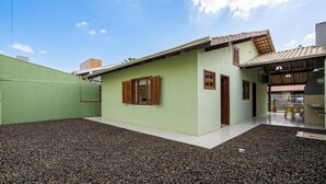 A single-story building with a flat roof, a small porch, and a gravel driveway. - House With Barbecue Grill (Picarras)