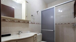 A bathroom with a sink, toilet, and shower. - House With Barbecue Grill (Picarras)