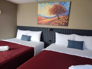 A hotel room with two beds, a painting of a tree and flowers on the wall, and a window. - Hotel Alcántara Boutique (San Salvador)