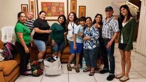 Un grupo de personas en una habitación con un cartel en la pared que dice 'Hotel Alcántara Boutique'.
