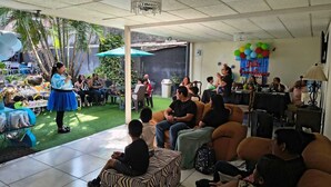 Evento interior con un escenario, asientos para el público y una pared decorada.
