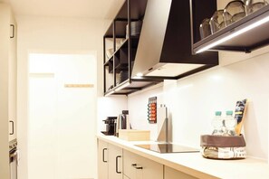 Une cuisine moderne équipée d’un four encastré, d’une machine à café et d’un four à micro-ondes.