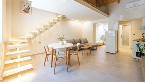 Ein modernes Interieur mit Treppe, Essbereich, Sofa und Küche.