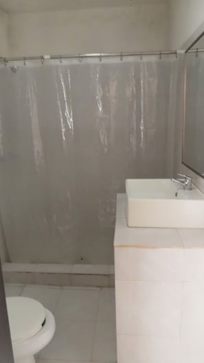 A bathroom with a shower curtain, a sink, and a toilet. - Depto. Puente Internacional 
Alojamiento entero vivienda rentada en Reynosa Méx, (Reynosa)