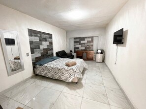 A bedroom with a bed, a chair, a TV, and a cabinet. - Depto. Puente Internacional 
Alojamiento entero vivienda rentada en Reynosa Méx, (Reynosa)