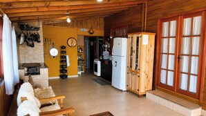 Una cucina con mobili in legno, un frigorifero e un'area pranzo con una panca.