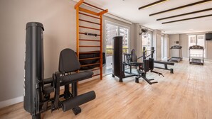 Un gimnasio con equipo de ejercicio, una barra de dominadas y una cinta de correr.