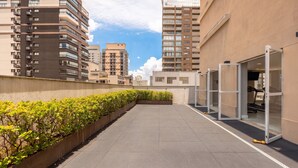 Terraza en la azotea con macetas alineadas, una cinta de correr y una puerta de cristal.