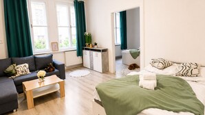 Quarto de hotel moderno com cama, sofá e uma pequena mesa.
