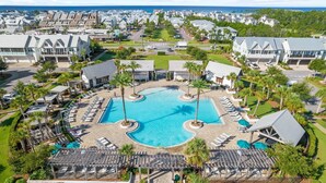 A resort with a central swimming pool, lounge areas, and a view of the ocean. - It's Boé Beach (Panama City Beach)