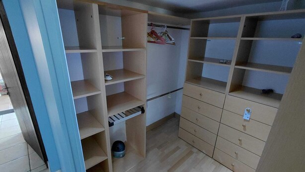 A room with a wooden wardrobe, a small shelf, and a hanging rack. - Basque-style house with a 300 m2 garden, a sunny veranda, and a plancha (Anglet)