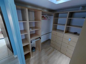 A room with a wooden wardrobe, a small shelf, and a hanging rack. - Basque-style house with a 300 m2 garden, a sunny veranda, and a plancha (Anglet)
