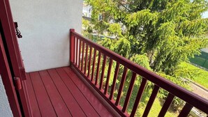 A red wooden deck with a white wall and a metal railing. - Basque-style house with a 300 m2 garden, a sunny veranda, and a plancha (Anglet)