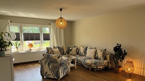 A living room with a sofa, a small table, a globe, and a plant. - Vacation Home Surrounded by Nature on Lake Kummerow (Dargun)