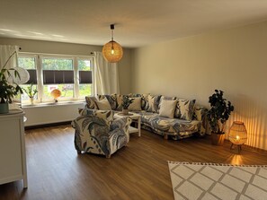 A living room with a sofa, a small table, a globe, and a plant. - Vacation Home Surrounded by Nature on Lake Kummerow (Dargun)