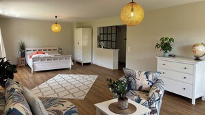 A modern bedroom with a bed, wardrobe, bedside table, and a large window. - Vacation Home Surrounded by Nature on Lake Kummerow (Dargun)