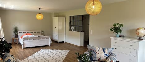 A modern bedroom with a bed, wardrobe, bedside table, and a large window.