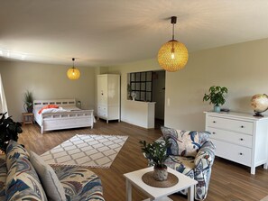 A modern bedroom with a bed, wardrobe, bedside table, and a large window. - Vacation Home Surrounded by Nature on Lake Kummerow (Dargun)