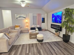 A modern living room with a sofa, coffee table, and TV. - Cozy Luxury Getaway near Frisco and Prosper (Krugerville)