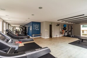 Ein Fitnessstudio mit Laufbändern, Gymbällen und Gewichten.