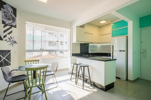 Eine moderne Küche mit Essbereich, einem Kühlschrank und Blick nach draußen.