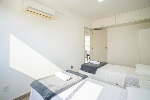 Ein Zimmer mit zwei Betten, einem Kleiderschrank und einem Fenster.