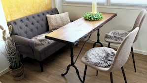 Una sala acogedora con un sofá capitonado, una mesa de centro de madera y un sillón con una manta de pelo.