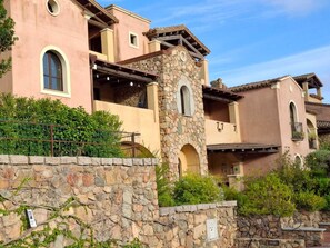 A multi-story building with a stone tower, arched windows, and balconies. - Relax in Villasimius (Villasimius)
