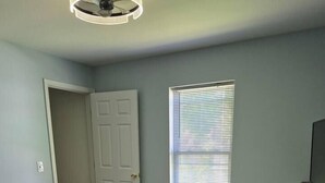 A bedroom with a bed, a dresser, a window with blinds, and a door. - Entire Home in Dover, DE/Close to Raceway/Casino (Dover)