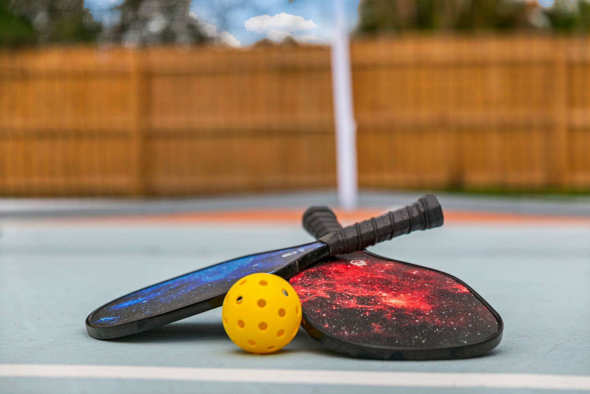 Twee paddleboards en een gele bal op een vlak oppervlak.