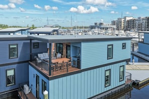 A modern multi-story building with a rooftop deck featuring outdoor furniture. - Palm Springs at The Cove Riverwalk Villas (Wilmington)