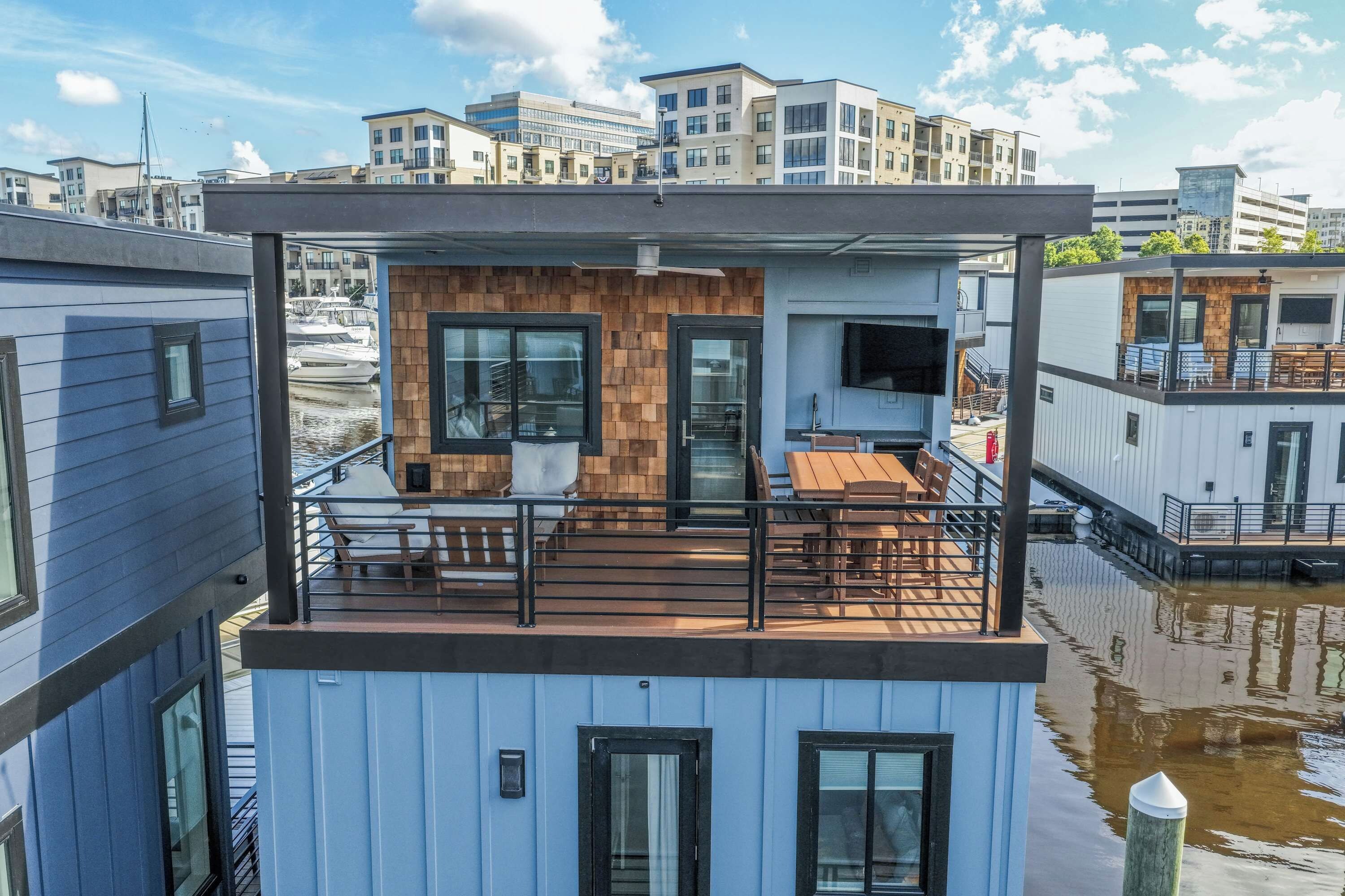 A modern multi-story building with a balcony, large windows, and a flat roof.