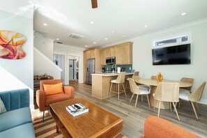 A modern living space with a kitchen, dining area, and seating. - Palm Springs at The Cove Riverwalk Villas (Wilmington)
