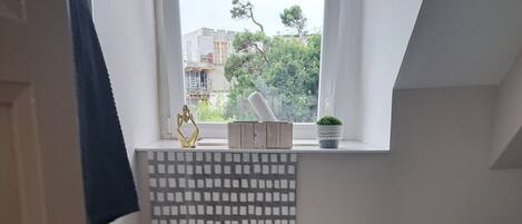 Un baño pequeño con inodoro, ventana y salpicadero de azulejos.