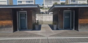 Un edificio moderno con dos puertas de madera y plantas en macetas.