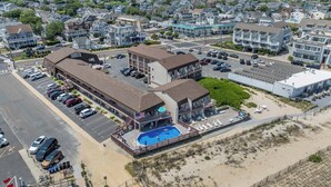 Un hotel con piscina, estacionamiento y vista a la playa.