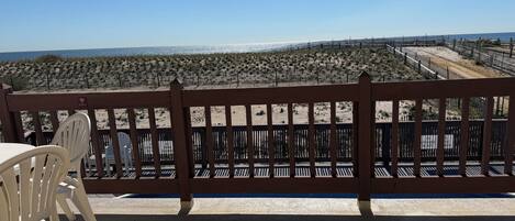 Una terrassa de fusta amb vista a la platja i l'oceà.