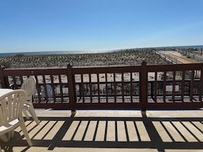 A wooden deck with a view of the beach and ocean. - Beachfront Apartment With Balcony & Views (Point Pleasant Beach)