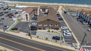 Un hotel de varios pisos con estacionamiento, situado cerca de una playa y vistas al océano.